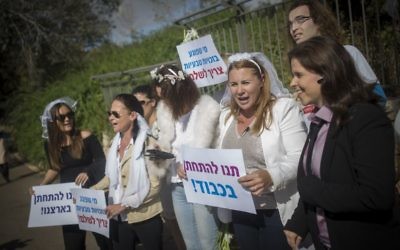 Des militantes, dont la députée de l'Union sioniste Ksenia Svetlova, 2e à droite, avec pancartes et voiles de mariées, pendant une manifestation pour le droit au mariage civil devant la Knesset, le 2 novembre 2016. (Crédit : Yonatan Sindel/Flash90)