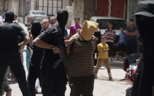 Un "collaborateur" présumé dans la bande de Gaza, maintenu par un homme armé du Hamas, quelques instants avant son exécution, le 22 août 2014. Illustration. (Crédit : capture d'écran YouTube) Un "collaborateur" présumé dans la bande de Gaza, maintenu par un homme armé du Hamas, quelques instants avant son exécution, le 22 août 2014. Illustration. (Crédit : capture d'écran YouTube)