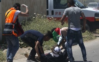 Les Palestiniens soignant 'un manifestant blessé lors d'affrontements avec l'armée israélienne dans le village de Beit Furik, à l'est de Naplouse, le 12 mai 2017 (Crédit : Jaafar Ashtiyeh / AFP)