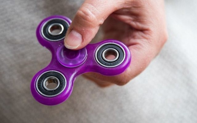 Sur cette illustration, une femme tient un fidget spinner, le 5 mai 2017 dans le quartier de Boropoklyn à New York. (Crédit : Drew Angerer/Getty Images/AFP) Sur cette illustration, une femme tient un fidget spinner, le 5 mai 2017 dans le quartier de Boropoklyn à New York. (Crédit : Drew Angerer/Getty Images/AFP)