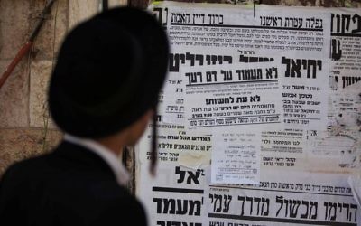Un Juif ultra-orthodoxe lit une affiche appelant à la libération d'un membre de la secte juive anti-sioniste Neturei Karta, le 1er août 2013. Illustration. (Crédit : Yonatan Sindel/Flash90)