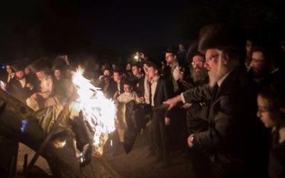 Des Juifs ultra-orthodoxes devant un immense feu de joie pendant la célébration de Lag BaOmer, dans le quartier de Mea Shearim, à Jérusalem, le 13 mai 2017. (Crédit : Flash90)