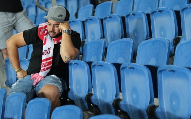 Un fan dépité regarde l'Hapoel Tel Aviv perdre ; l'équipe chute en deuxième division, le 13 mai 22017. (Crédit : Roy Alima/Flash90) Un fan dépité regarde l'Hapoel Tel Aviv perdre ; l'équipe chute en deuxième division, le 13 mai 22017. (Crédit : Roy Alima/Flash90)