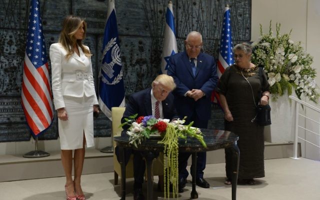 Le président Reuven Rivlin derrière son homologue américain Donald Trump, qui signe le livre d'or, avec leurs épouses Melania Trump et Nechama Rivlin, à la résidence présidentielle de Jérusalem, le 22 mai 2017. (Crédit : Haim Zach/GPO) Le président Reuven Rivlin derrière son homologue américain Donald Trump, qui signe le livre d'or, avec leurs épouses Melania Trump et Nechama Rivlin, à la résidence présidentielle de Jérusalem, le 22 mai 2017. (Crédit : Haim Zach/GPO)