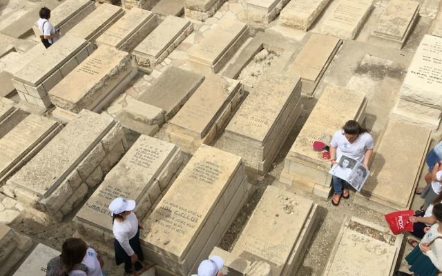Un groupe de lycéens écoute des histoires sur les soldats israéliens tombés au combat, sur le Mont des Oliviers, durant Yom Hazikaron 2017. (Crédit : Jessica Steinberg/Times of Israel)Mont des Olivi