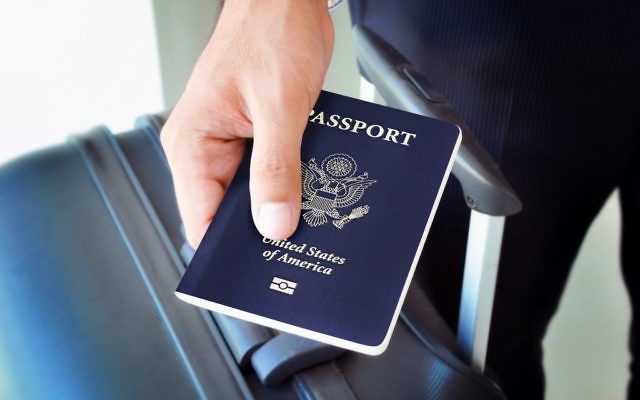 Homme tenant un passeport américain (Crédit : Shutterstock)
