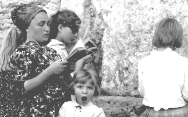 Une mère et ses filles prient au mur Occidental, pendant que la plus jeune baille, le 17 juin 1967. (Crédit : collection de Dan Hadani/Bibliothèque nationale d'Israël) Une mère et ses filles prient au mur Occidental, pendant que la plus jeune baille, le 17 juin 1967. (Crédit : collection de Dan Hadani/Bibliothèque nationale d'Israël)