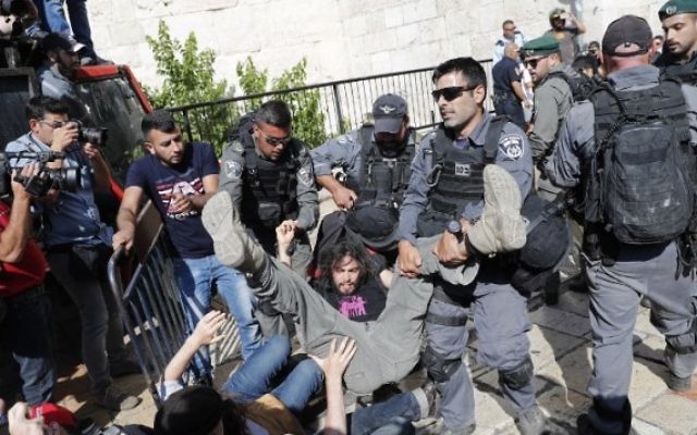 Altercation entre des activistes de la paix et la police israélienne devant la porte de Damas, dans la Vieille ville de Jérusalem, le 24 mai 2017, avant la traditionnelle marche des drapeaux de Yom Yeroushalayim. (Crédit : AFP Photo/Thomas COEX)