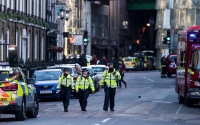 Des agents de police et des véhicules d'urgence dans la rue située aux abords de Borough Market, le 4 juin 2017, lors de la matinée qui a suivi une attaque terroriste sur le pont de Londres et le quartier de Borough à Londres. (Crédit : CHRIS J RATCLIFFE/AFP PHOTO)