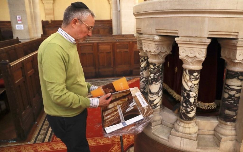 Jacques Canet, président de la Grande Synagogue de Paris (Synagogue de la Victoire), lisant un livre consacré au 150e anniversaire de la synagogue, à Paris le 8 juin 2017 (Crédit : AFP PHOTO / JACQUES DEMARTHON