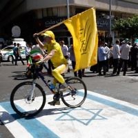 Un Iranien roule sur une reproduction du drapeau israélien dans une rue de Téhéran pendant la Journée d'Al-Qods, le 23 juin 2017. (Crédit: Stringer/AFP)