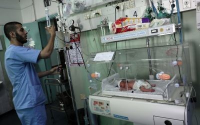 Un infirmier palestinien prenant soin d'un nouveau-né à l'unité de néonatalogie à l'hôpital des Emirats arabes unis à Rafah, dans le sud de la bande de Gaza, le 27 juin 2017. (Crédit : Said Khatib/AFP)