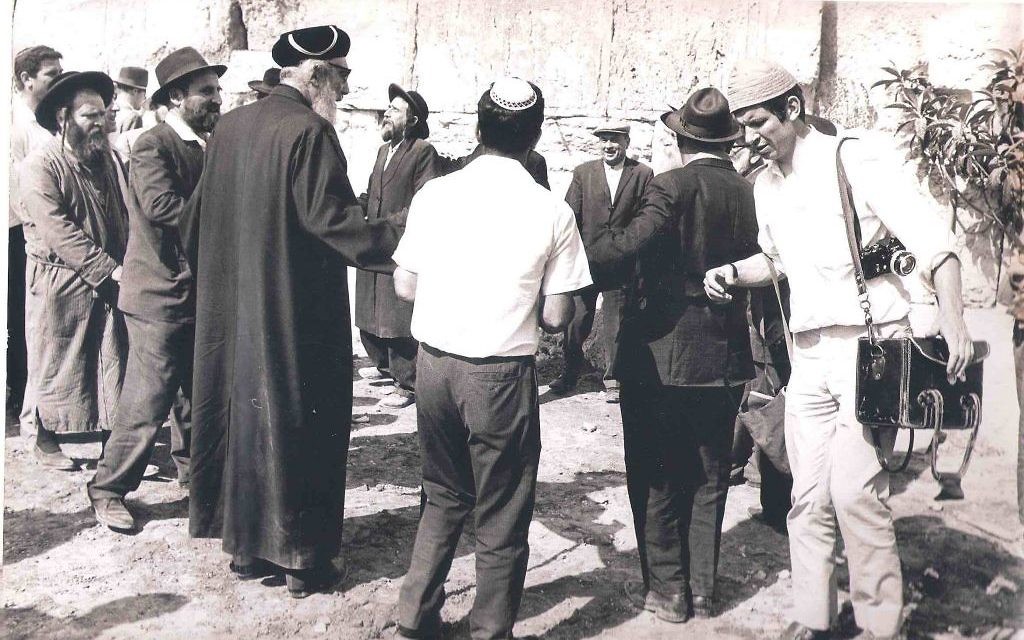 Le photoreporter Jacques Héripret, à droite, devant le mur Occidental avec ses appareils photo, le 6 juin 1967. (Crédit : Collection Jacques Héripret)