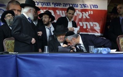 Le chef du parti Yachad Eli Yishai embrasse la main du rabbin Meir Mazuz lors d'une conférence de presse à Bnei Brak, le 25 décembre 2014 (Crédit : Yaakov Naumi / Flash90)