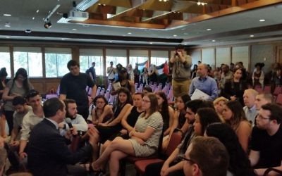 Le maire de Jérusalem Nir Barkat s'adresse à des étudiants de l'université de San Francisco le 6 avril 2016, alors que des manifestants pro-palestiniens protestent dans le fond de la salle (Crédit : Municipalité de Jérusalem)
