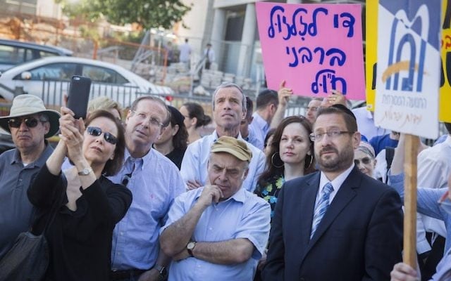 Natan Sharansky,  au centre, président de l'Agence juive, et Dov Lipman, alors député, en costume cravate à droite, lors d'une manifestation organisée par les Juifs orthodoxes américains et israéliens et les Juifs conservateurs devant les bureaux du grand-rabbinat à Jérusalem, le 6 juillet 2016 (Crédit : Hadas Parush/Flash90)