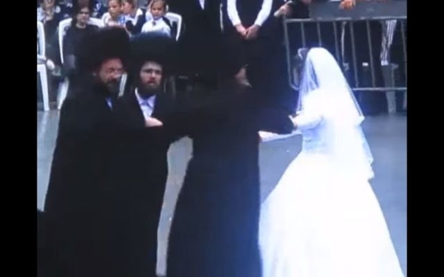 Le rabbin de Karlin-Stolin au mariage de sa fille. Il danse avec sa fille, le jeune marié et son père, à Tel Aviv le 25 juin 2017. (Crédit : capture d'écran YouTube) Le rabbin de Karlin-Stolin au mariage de sa fille. Il danse avec sa fille, le jeune marié et son père, à Tel Aviv le 25 juin 2017. (Crédit : capture d'écran YouTube)