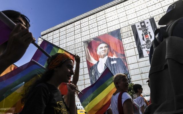 Des activistes LGBTQ brandissent des drapeaux pendant qu'ils défilent, le 2 juillet 2014, à Istanbul, en dépit de l'interdiction du gouvernement. (Crédit : AFP / BULENT KILIC) Des activistes LGBTQ brandissent des drapeaux pendant qu'ils défilent, le 2 juillet 2014, à Istanbul, en dépit de l'interdiction du gouvernement. (Crédit : AFP / BULENT KILIC)