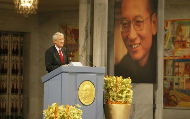 Photo prise le 10 décembre 2010. Le président de la Commission Nobel Thorbjorn Jagland lors d'une cérémonie à Oslo devant la photo du lauréat du prix Nobel de la Paix, Liu Xiaobo, décédé le 13 juillet 2017. (Crédit : AFP PHOTO / NTB Scanpix / Heiko JUNGE / Norway OUT) Photo prise le 10 décembre 2010. Le président de la Commission Nobel Thorbjorn Jagland lors d'une cérémonie à Oslo devant la photo du lauréat du prix Nobel de la Paix, Liu Xiaobo, décédé le 13 juillet 2017. (Crédit : AFP PHOTO / NTB Scanpix / Heiko JUNGE / Norway OUT)