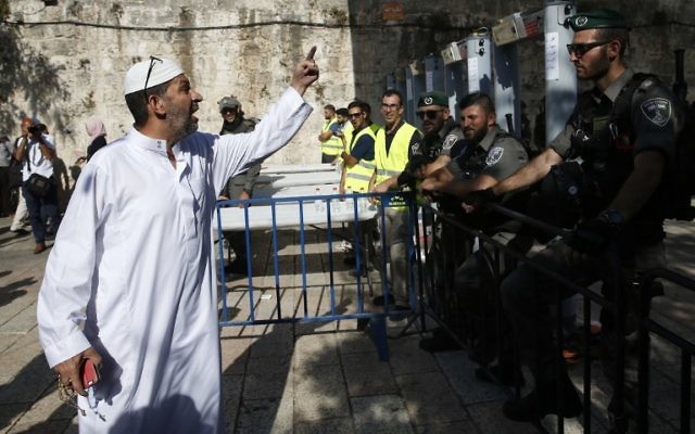 Un Palestinien interpelle les garde-frontières israéliens se tenant à côté des nouveaux détecteurs de métaux à l'entrée principale du mont du Temple dans la Vieille ville de Jérusalem, le 16 juillet 2017, après la réouverture de ce site ultra-sensible (Crédit : AHMAD GHARABLI/AFP PHOTO) Un Palestinien interpelle les garde-frontières israéliens se tenant à côté des nouveaux détecteurs de métaux à l'entrée principale du mont du Temple dans la Vieille ville de Jérusalem, le 16 juillet 2017, après la réouverture de ce site ultra-sensible (Crédit : AHMAD GHARABLI/AFP PHOTO)