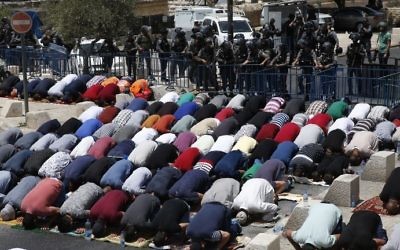 Les gardes-frontières israéliens surveillent les fidèles musulmans palestiniens qui prient en dehors de la Vieille mille de Jérusalem surplombant le mont du Mont du Temple le 28 juillet 2017 (Crédit : AFP PHOTO / AHMAD GHARABLI)