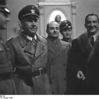 René Bousquet (avec col de fourrure, le 2e en partant de la droite) entouré par, de gauche à droite, le SS-Sturmbannführer Bernhard Griese (en manteau de cuir), le préfet régional Antoine Lemoine, le chef local de la Sipo et du SD Rolf Mühler (de) (derrière Lemoine), l'administrateur de Marseille Pierre BarraudN 6, à l'hôtel de ville de Marseille le 23 janvier 1943, pendant la rafle de Marseille (Crédit : CC BY-SA 3.0 de)