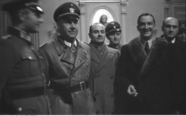 René Bousquet (avec col de fourrure, le 2e en partant de la droite) entouré par, de gauche à droite, le SS-Sturmbannführer Bernhard Griese (en manteau de cuir), le préfet régional Antoine Lemoine, le chef local de la Sipo et du SD Rolf Mühler (de) (derrière Lemoine), l'administrateur de Marseille Pierre BarraudN 6, à l'hôtel de ville de Marseille le 23 janvier 1943, pendant la rafle de Marseille (Crédit : CC BY-SA 3.0 de) René Bousquet (avec col de fourrure, le 2e en partant de la droite) entouré par, de gauche à droite, le SS-Sturmbannführer Bernhard Griese (en manteau de cuir), le préfet régional Antoine Lemoine, le chef local de la Sipo et du SD Rolf Mühler (de) (derrière Lemoine), l'administrateur de Marseille Pierre BarraudN 6, à l'hôtel de ville de Marseille le 23 janvier 1943, pendant la rafle de Marseille (Crédit : CC BY-SA 3.0 de)