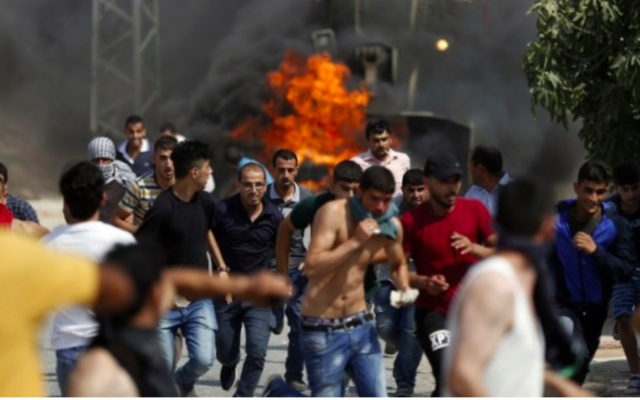 Les jeunes palestiniens lors des affrontements dans le village de Koubar, à l'ouest de Ramallah, le 22 juillet 2017, alors que les forces israéliennes tentent de fermer les routes menant au village. (Crédit : AFP / Abbas Momani)