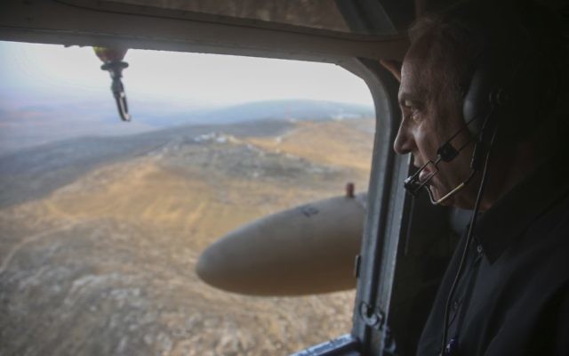 Le Premier ministre israélien Benjamin Netanyahu regarde la vue depuis un hélicoptère alors qu'il s'apprête à visiter la nouvelle barrière entre Israël et le territoire de Cisjordanie dans la zone de Tarqumiyah, le 20 juillet 2016 (Crédit :Marc Israel Sellem/POOL)