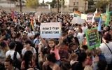Une petite fille brandit un panneau "J'ai deux papas et je suis heureuse" alors que des milliers de personnes manifestent pour le droit des couples LGBT à adopter, à Tel Aviv, le 20 juillet 2017. (Crédit : Tomer Neuberg/Flash90)