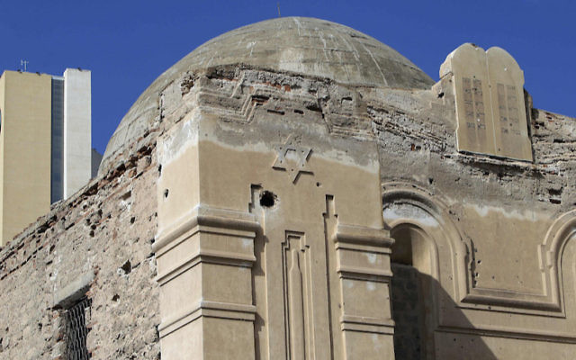 Un hôtel peut être aperçu derrière la synagogue abandonnée de  Dar Bishi à Tripoli,  en Libye le 28 septembre 2011 (Crédit : Joseph Eid/AFP/Getty Images/via JTA)