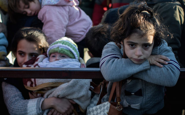 Une fillette attend dans la queue menant à la porte d'un poste-frontière, alors qu'un petit nombre de Syriens est autorisé à retourner en Syrie au poste frontalier fermé de Killis, en Turquie, le 8 février 2016.  (Crédit : Chris McGrath/Getty Images)