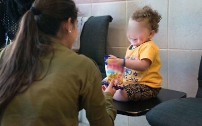 Une soldate israélienne avec un enfant syrien en Israël, dans le cadre de l'opération Bon voisin d'aide humanitaire aux Syriens touchés par la guerre civile. Photographie non datée, publiée le 19 juillet 2017. (Crédit : armée israélienne)