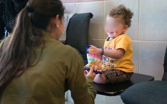 Une soldate israélienne avec un enfant syrien en Israël, dans le cadre de l'opération Bon voisin d'aide humanitaire aux Syriens touchés par la guerre civile. Photographie non datée, publiée le 19 juillet 2017. (Crédit : armée israélienne) Une soldate israélienne avec un enfant syrien en Israël, dans le cadre de l'opération Bon voisin d'aide humanitaire aux Syriens touchés par la guerre civile. Photographie non datée, publiée le 19 juillet 2017. (Crédit : armée israélienne)