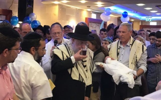 Les membres de la famille Salomon assistent à la circoncision de leur fils, Ari Yosef, dans la ville centrale d'Elad d'Israël, le 27 juillet 2017. (Crédit : Jacob Magid / Times of Israel)