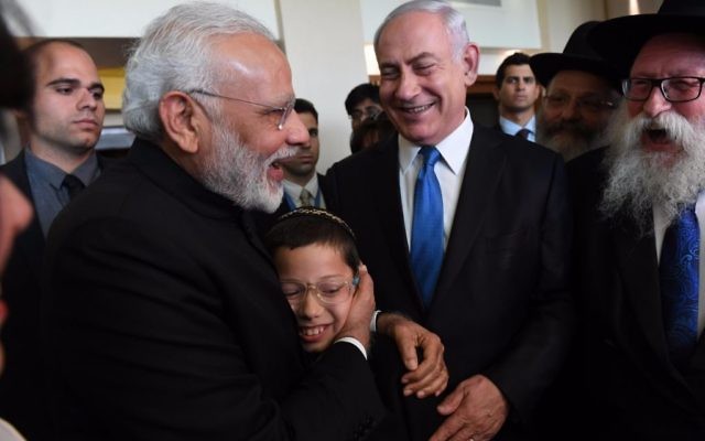 Moshe Holtzberg, le fils de deux émissaires Habad tués dans un attentat en novembre 2008 à Bombay dans les bras du Premier ministre indien Narendra Modi, avec le Premier ministre Benjamin Netanyahu, en Israël, le 5 juillet 2017. (Crédit : Raphael Ahren/Times of Israël)