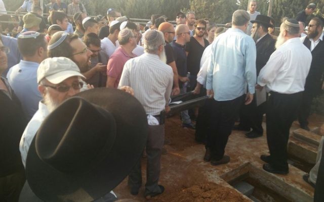 Des milliers de personnes se sont réunies dans le cimetière municipal de Modiin dans le centre d'Israël pour les funérailles des trois membres de la même famille assassinés ce week-end durant un attentat terroriste commis au sein de l'implantation de Halamish (Crédit : Raoul Wootliff/Times of Israel)