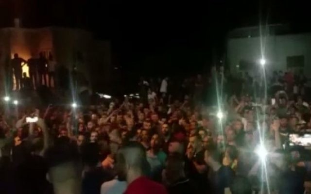 Quelque 3 000 personnes se sont rassemblées mercredi à Umm al-Fahm pour l'enterrement des trois Arabes-Israéliens qui ont abattu des agents de police druzes (Crédit : capture d'écran Dixième chaîne)