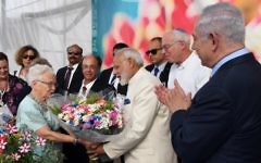 Le Premier ministre indien, au centre en blanc, reçoit un bouquet de fleurs pendant sa visite à la ferme Dan, accompagné du Premier ministre Benjamin Netanyahu, tout à droite, le 4 juillet 2017. (Crédit : Haim Tzach/GPO)