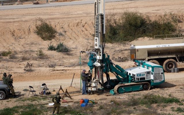 Cette photo datant du 10 février 2016 montre que les soldats de l'armée israélienne surveillent une machine qui forage pour creuser du côté israélien de la frontière avec la bande de Gaza alors qu'ils cherchent des tunnels utilisés par des terroristes palestiniens qui envisagent d'attaquer Israël (Crédit : AFP / Menahem Kahana)