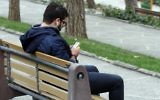 Un Iranien avec son smartphone dans un parc de Téhéran, le 1er décembre 2015. (Crédit : Atta Kenare/AFP)