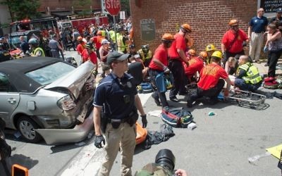 Secouristes et policiers sur les lieux d'une attaque à la voiture bélier, visible à gauche, conduite par James Fields, contre des manifestants anti-racistes, à Charlottesville, en Virginie, le 12 aout 2017. (Crédit : Paul J. Richards/AFP)