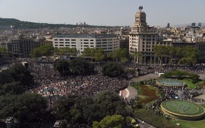 L'assistance quitte la Plaza de Catalunya après avoir observé une minute de silence pour les victimes de l'attentat de Barcelone le 18 août 2017, vingt-quatre heures après qu'une fourgonnette a foncé dans la foule, faisant 13 morts et blessant plus de 100 personnes dans le quartier Las Ramblas de Barcelone (Crédit :  / AFP PHOTO / LLUIS GENE)