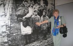 Eva Mozes Kor, jumelle de Mengele, devant sa photographie au musée du mémorial d'Auschwitz, en  2007. (Crédit : autorisation)
