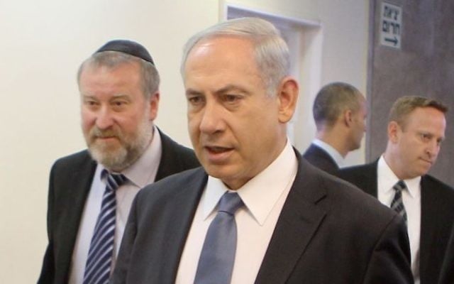 Le Premier ministre Benjamin Netanyahu, au centre, entouré d'Avichai Mandelblit, à gauche, alors secrétaire du cabinet, et d'Ari Harow, qui était son directeur de cabinet, en mars 2014. (Crédit : Danny Meron/Pool/Flash90)