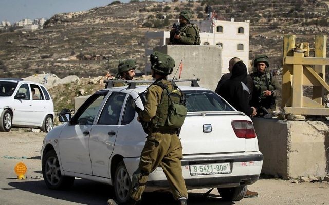 Illustration. Des soldats de l'armée israélienne contrôlent des voitures palestiniennes à un barrage routier situé dans le village de Yatta, en Cisjordanie, le 10 février 2017 (Crédit :Wisam Hashlamoun/Flash90)
