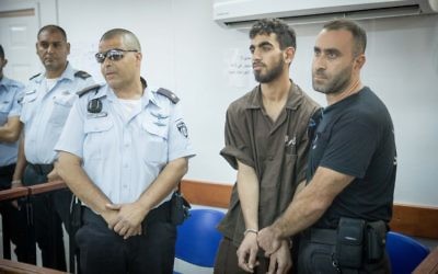 Omar Al-Abed, menotté, est présenté devant une salle d'audience pour son procès au tribunal militaire d'Ofer à proximité de Ramallah, en Cisjordanie, le 17 août 2017 (Crédit :  Yonatan Sindel/Flash90)