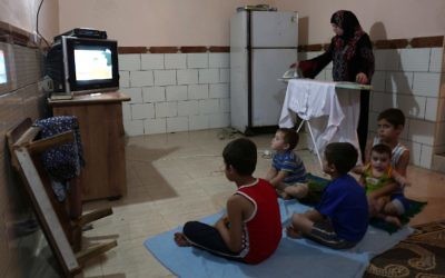 Une femme palestinienne repasse pendant les quelques heures d'approvisionnement en électricité, à Rafah, dans le camp de réfugiés au sud de la bande de Gaza, le 31 juillet 2017. (Crédit : AFP/SAID KHATIB)