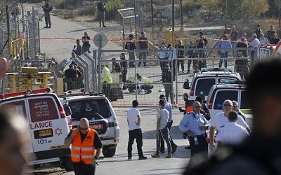 Les secouristes et les forces de sécurité sur la scène d'un attentat terroriste perpétré à l'entrée de l'implantation de Har Adar le 26 septembre 2017 (Crédit : AFP Photo/ Menahem Kahana)