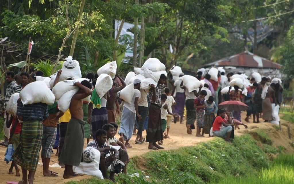 Des réfugiés musulmans Rohingya transportent de la nourriture distribuée par l'armée du Bangladesh au camp de réfugiés Balukhali près de Gumdhum, le 26 septembre 2017. (Crédit : AFP PHOTO/Dominique FAGET) Des réfugiés musulmans Rohingya transportent de la nourriture distribuée par l'armée du Bangladesh au camp de réfugiés Balukhali près de Gumdhum, le 26 septembre 2017. (Crédit : AFP PHOTO/Dominique FAGET)
